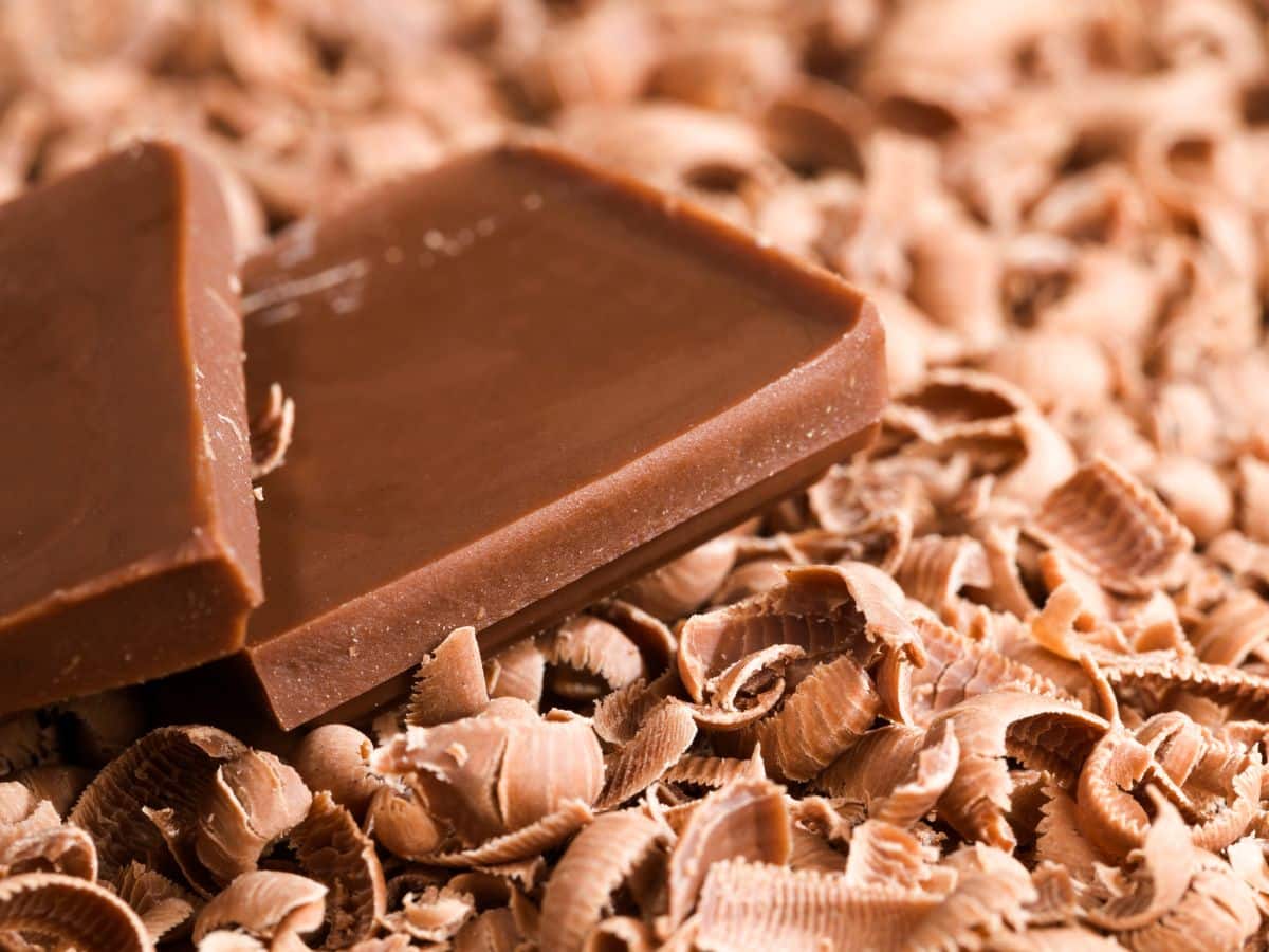 Milk chocolate squares on top of milk chocolate shavings