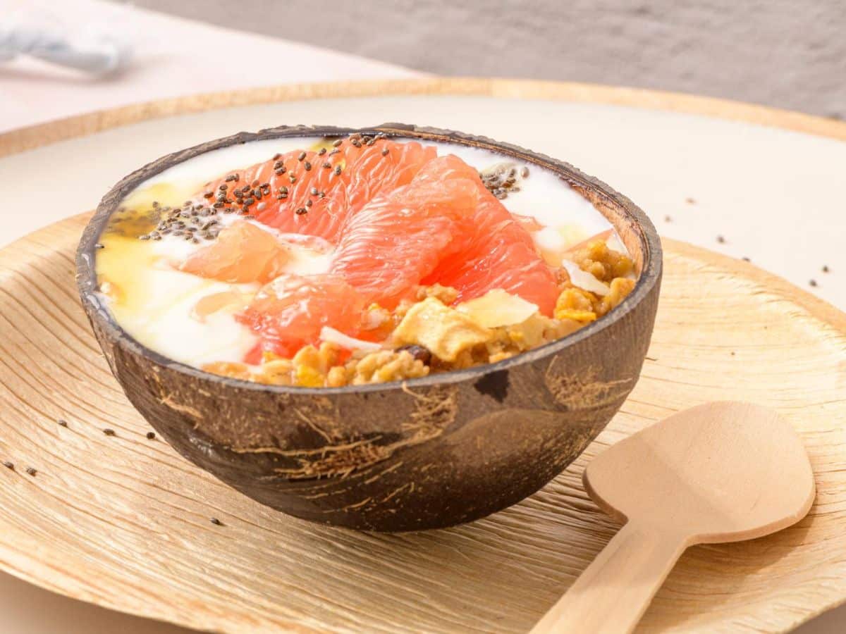 A bowl of yogurt topped with fruit and chia seeds.