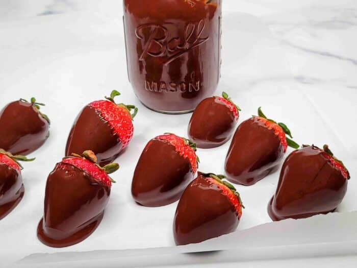 Chocolate covered strawberries on parchment paper.