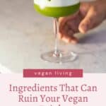 A person holding a glass with a green vegan drink topped with a basil leaf, with text about vegan ingredients impacting vegan drinks.