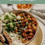 A bowl of rice topped with chickpeas in sauce, chopped cucumbers, fresh herbs, and pieces of flatbread, with a striped cloth in the background. Text reads: "How to Eat More Protein on a Tight Budget.