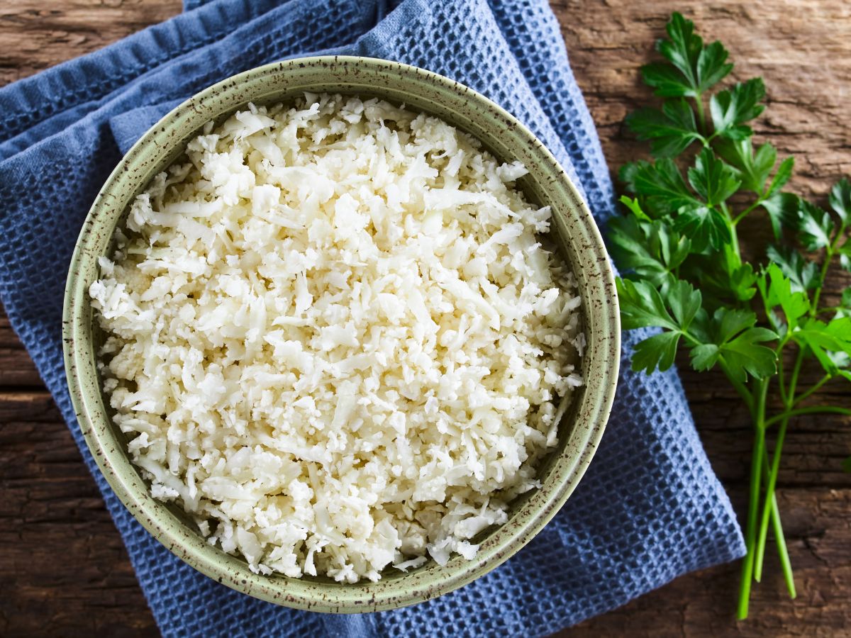 A bowl of cauliflower rice on a blue napkin.