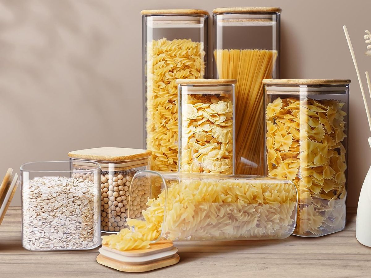 A set of clear storage containers filled with pasta and rice.