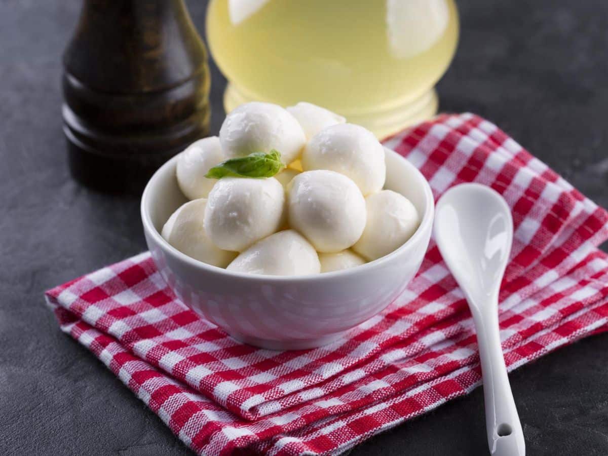 A bowl of gnocchi in a white bowl with a spoon.