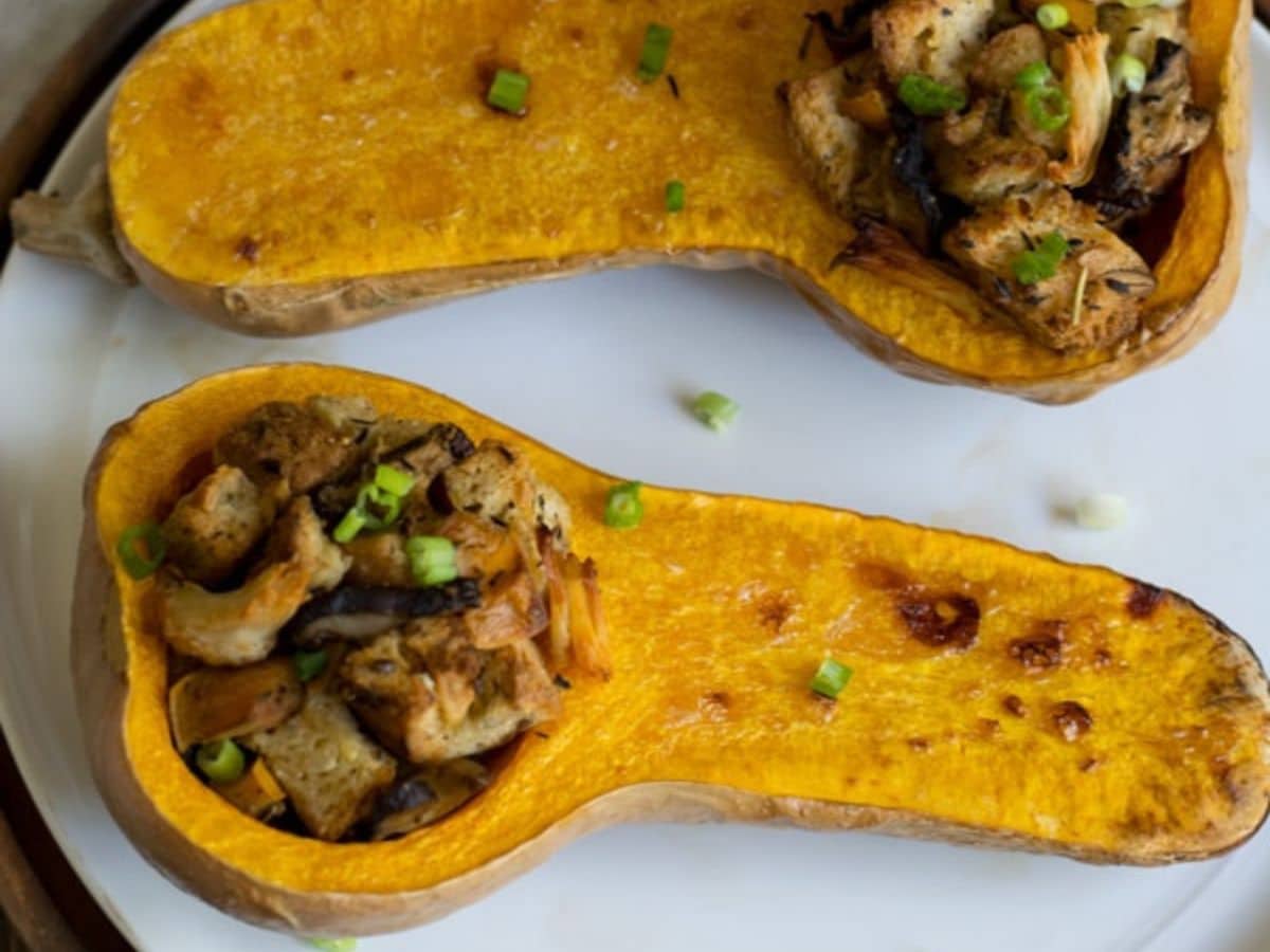 Two stuffed butternut squash on a plate.