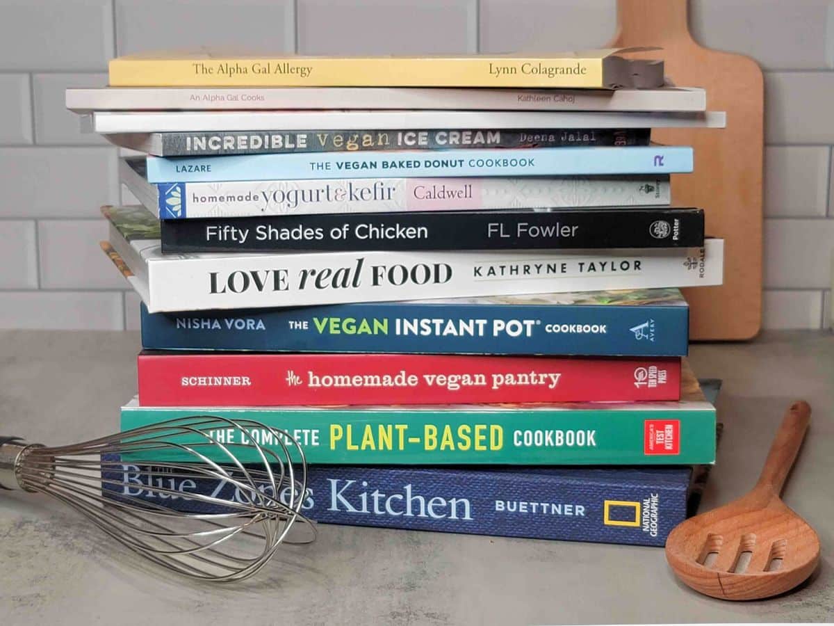 The best cookbooks for alpha-gal syndrome stacked on a kitchen counter.