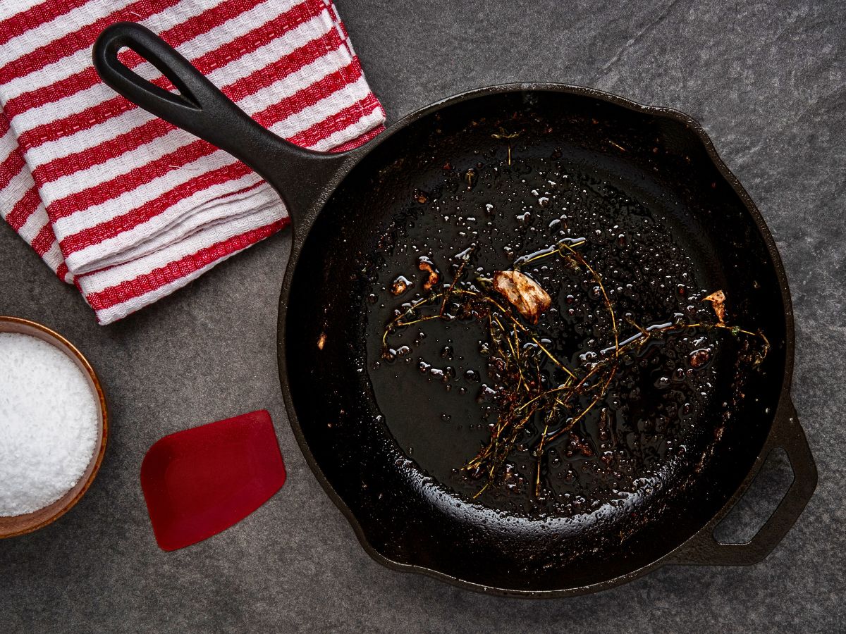A cast iron skillet with food residue waiting to be cleaned.