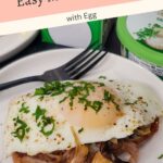 A slice of toast topped with sautéed mushrooms, a sunny side up egg, and chopped herbs on a white plate.