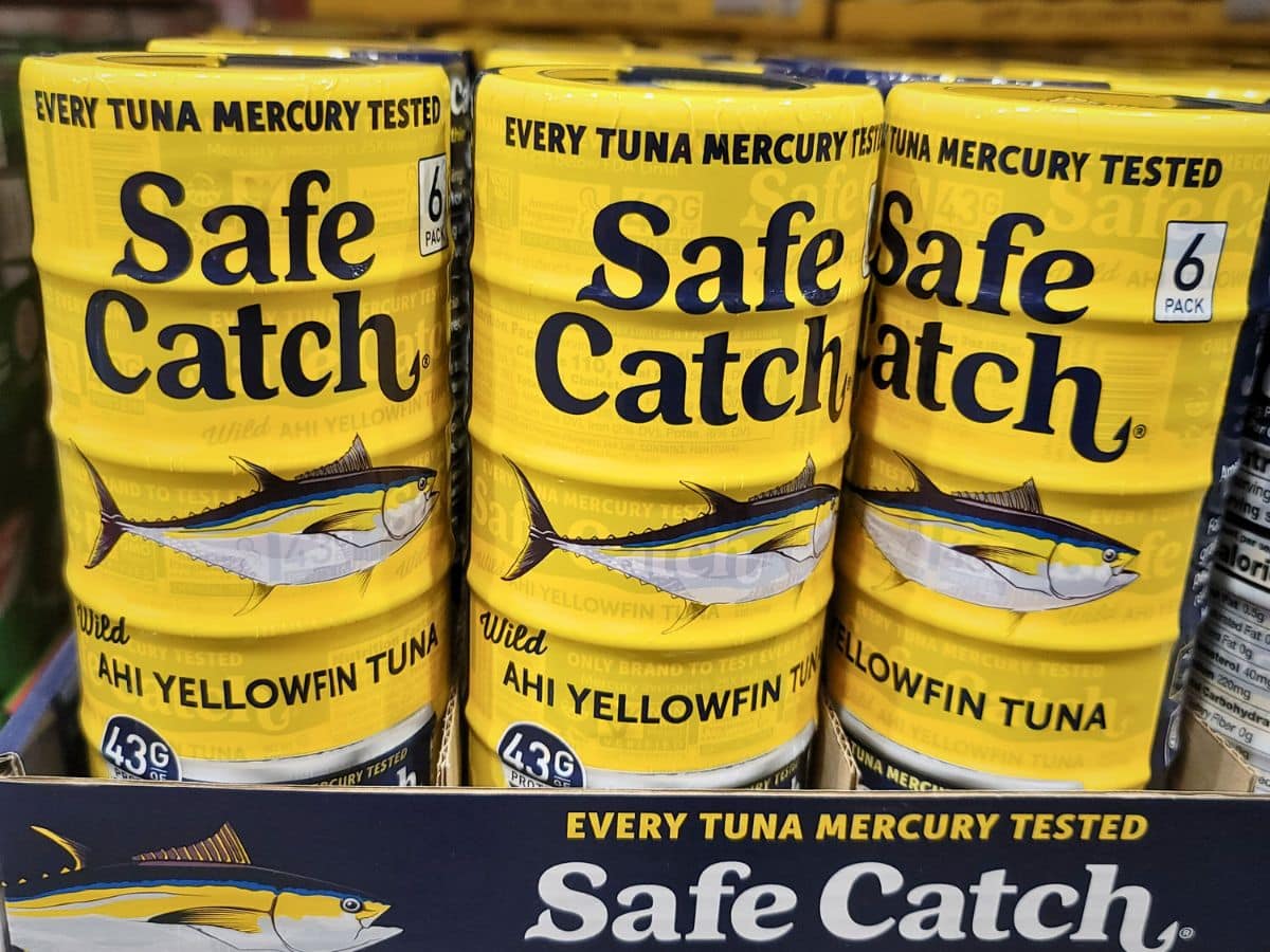 Several cans of Safe Catch Wild Ahi Yellowfin Tuna are stacked on display, each labeled with "Every Tuna Mercury Tested" and featuring an illustration of a tuna fish.